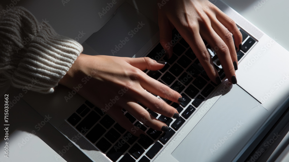Close-up of a person's hands typing on the keyboard of a modern laptop Close-up of a person's hands typing on the keyboard of a modern laptop