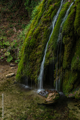 Piccola cascata in lunga esposizione con muschio nel bosco photo