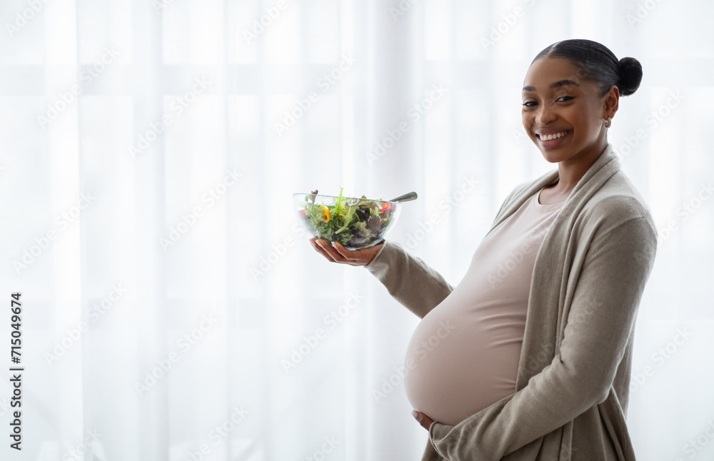 Happy young black lady expectant holding fresh vegetable salad Happy young black lady expectant holding fresh vegetable salad