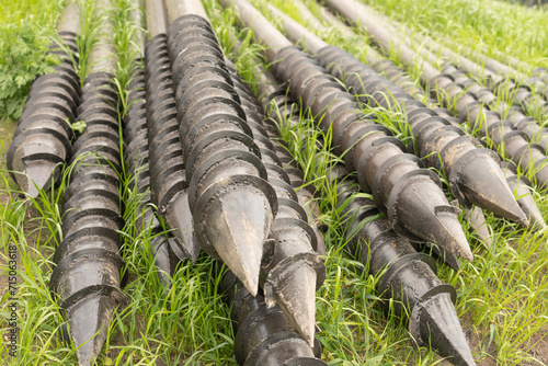 Screw piles for terrace foundations. Geo screws are steel round elements of an engineering structure. Industrial maintenance of metal tools for architectural construction work.