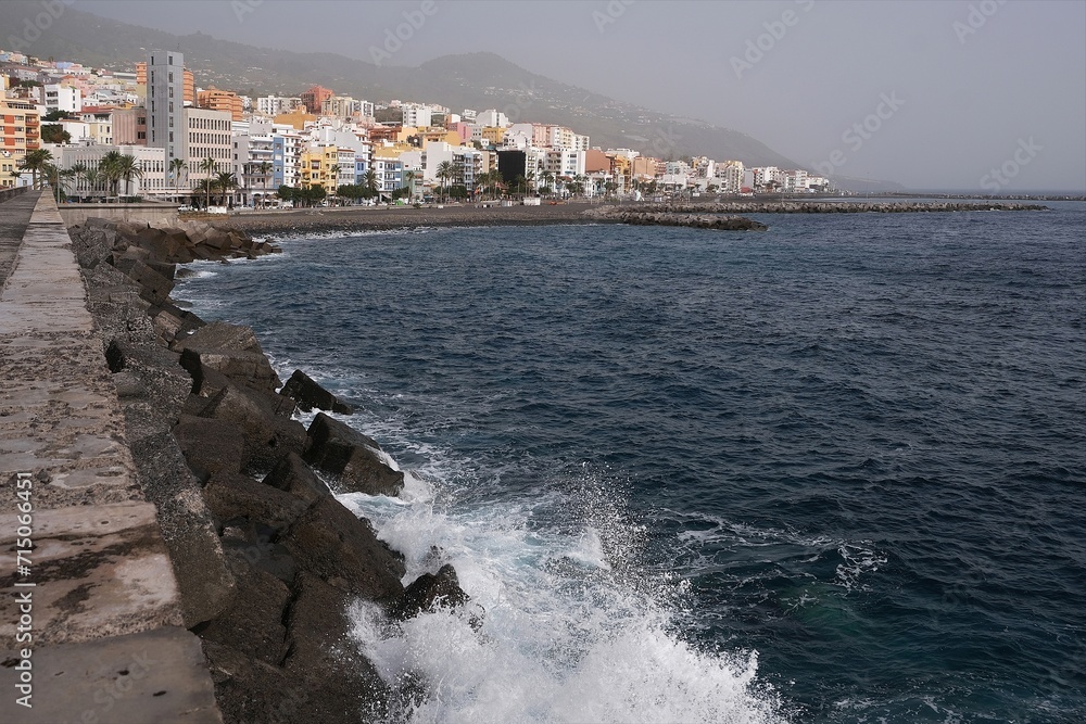 Panorama of Santa Cruz de la Palma and concrete pier in port with big waves of ocean. Canary Islands, Spain