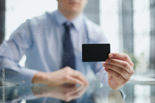 A man holds a black business card. A paper in the hands of a man. Prepared for your text.