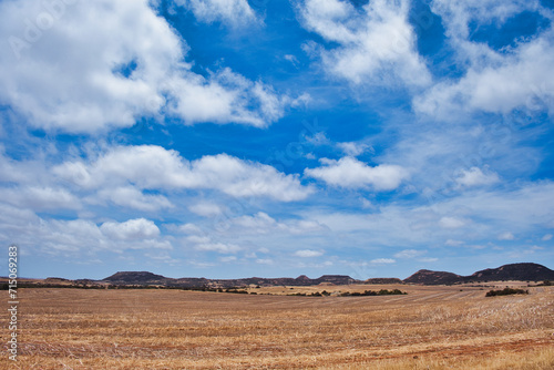 Characteristic landscape in the northern part of the Western Australian Wheatbelt, between Geraldton and Northampton. Rolling fields an barren hills under a blue sky with white clouds