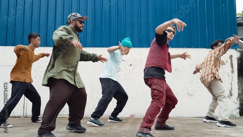 Fotografie Group of hip hop choreographer dancing street dance together at wall