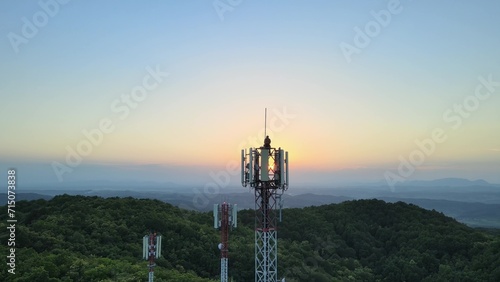Aerial view of a Engineer doing maintenance on Radio towers in the mountains
