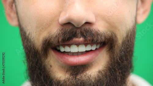 Man's mouth, close-up, on a green background