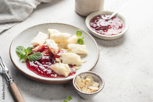 Lazy dumplings, vareniki with raspberry jam decorated with almond petals and mint leaves. Boiled cottage cheese homemade gnocchi with text space