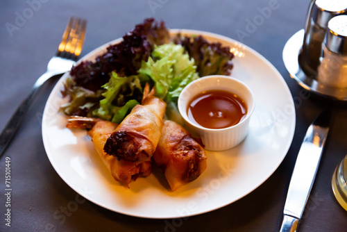 Crispy spring rolls with shrimps served with lettuce mix and sweet and sour sauce. Popular Thai appetizer