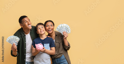 Photos Black family holding money cash and piggy bank, copy space