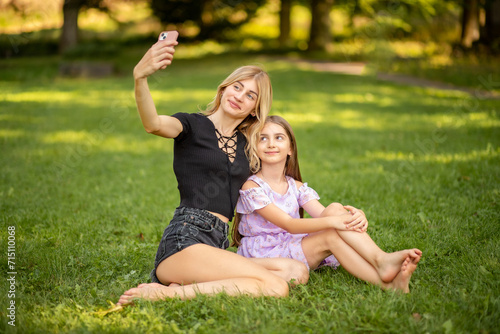 Mother and daughter taking a selfie in the park © InfiniteStudio