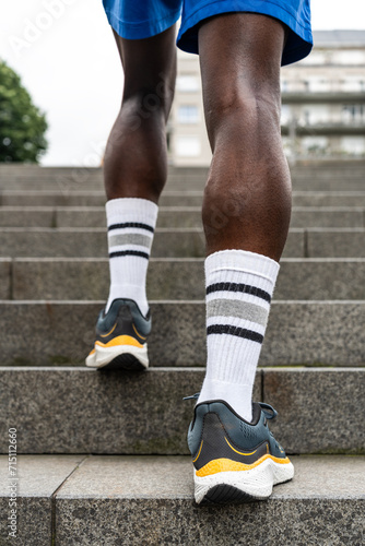 Stylish Ascent: Close-up of Legs of Black Athlete on Urban Stairs