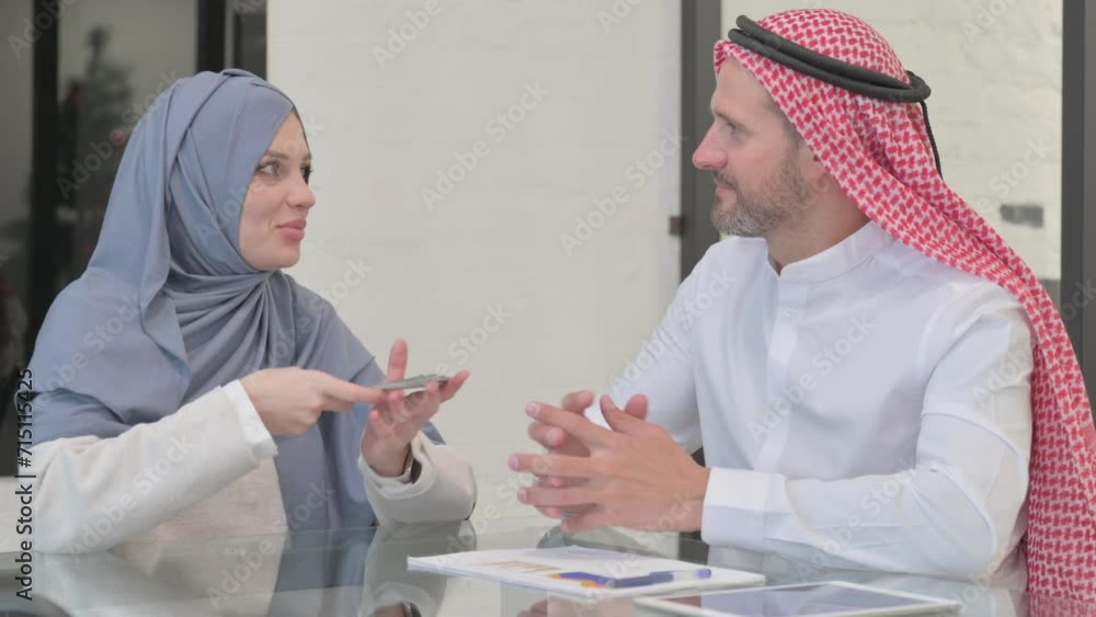 Arab Man giving Money to Woman in Office Arab Man giving Money to Woman in Office