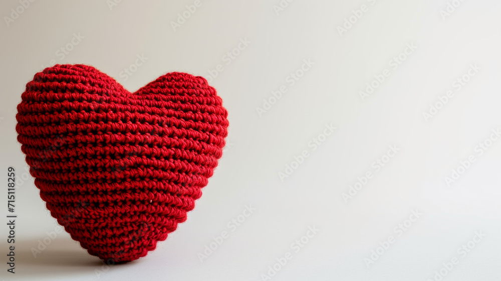 Fototapeta premium Amigurumi little heart. Handicraft cute Crocheted doll. Isolated on white background. Love symbol postcard, health concept or Valentine's day banner.
