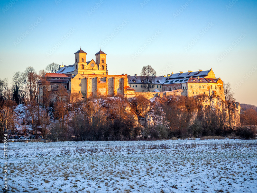 Tyniec near Krakow, Poland. Benedictine abbey and monastery on the rocky cliff at Vistula River in winter in sunset light