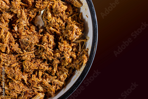 Close up of a bowl of red ancho chili pulled pork ready to use as a filling