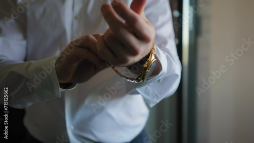Man wears a gold watch on his arm photo