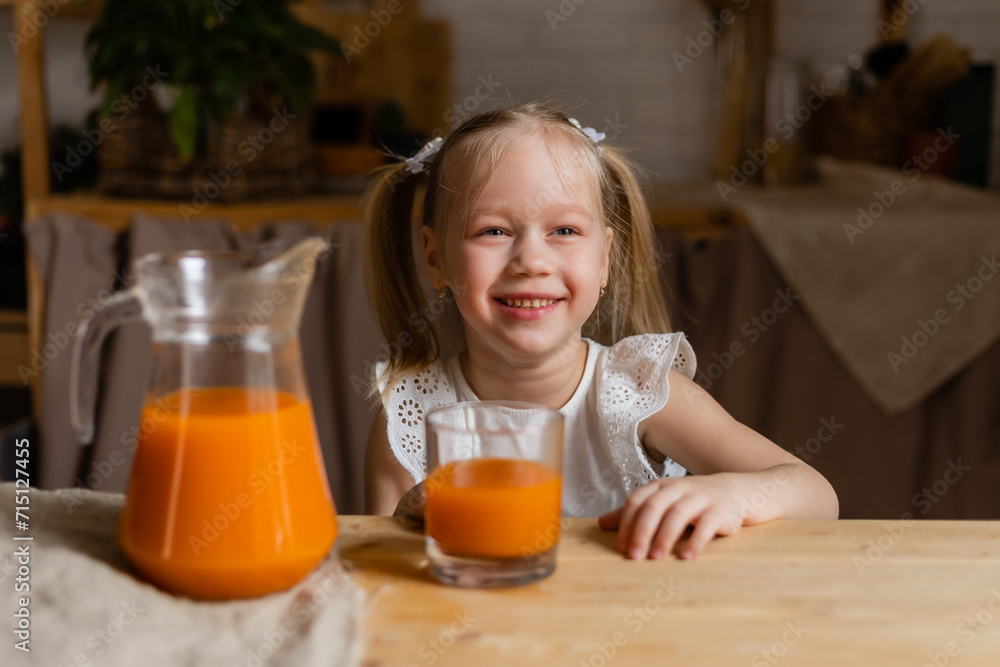 Cute little blonde girl drinking fresh orange juice in the kitchen Cute little blonde girl drinking fresh orange juice in the kitchen