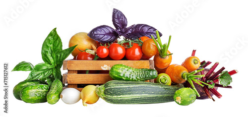 Fresh vegetables in rustic wooden box. Basil leaves, cucumbers, zuccini, carrots and tomatoes from the kitchen garden. Organic natural food. Isolated on white background