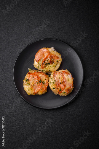 Delicious baked fish fillet with cheese, tomatoes, salt, spices and herbs