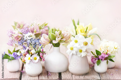Delicate blooming light springtime flowers in vases  spring blossoming floral festive background  bouquets floral card  selective focus  shallow DOF