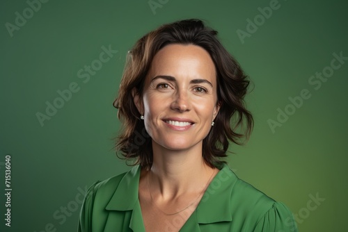 Portrait of a beautiful middle-aged woman smiling against a green background