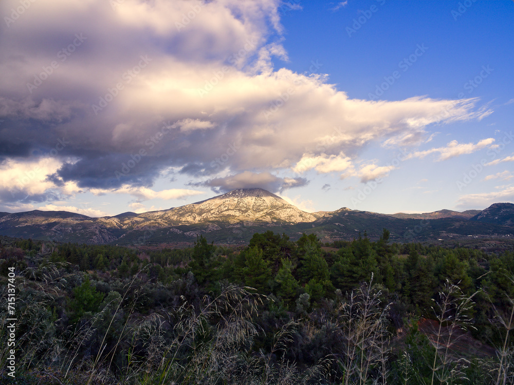 Fototapeta premium Mountain peak in sunset clouds. Dirfi mountain is located in Euboea island, Greece 