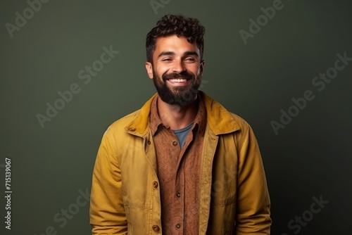 Portrait of a handsome young man smiling against a dark green background