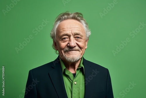 Portrait of a happy senior man looking at camera on green background
