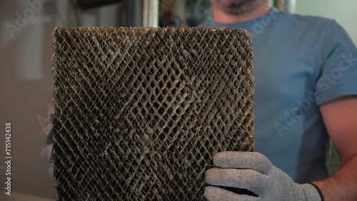 Worker HVAC services changing a folded dirty air filter in the HVAC furnace system in home. Close up shot photo
