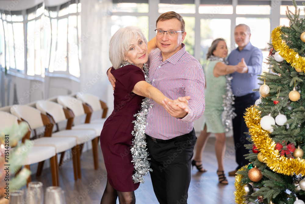 Couple of mature woman and male middle-aged partner incendiary dance lindy hop during New Year party for single people. Entertaining hobby, learning dance moves.