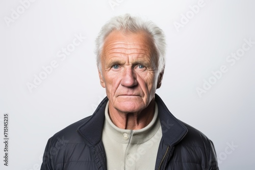 Senior man making funny face over grey background. Looking at camera.