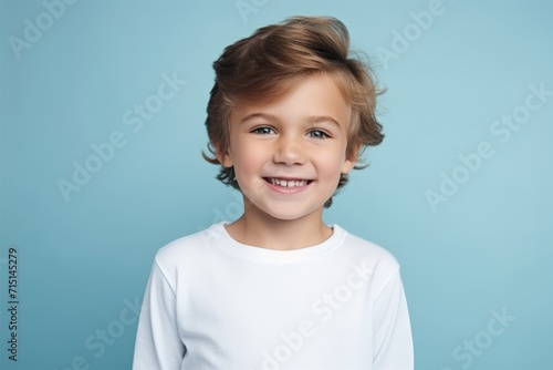 Portrait of a cute little boy on a blue background looking at the camera