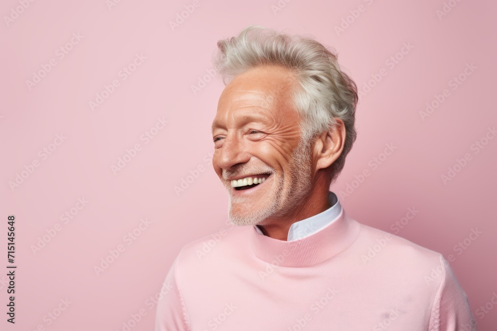 Portrait of a smiling senior man in pink sweater on pink background Portrait of a smiling senior man in pink sweater on pink background