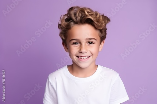 Portrait of a cute little boy with blond hair, isolated on purple background