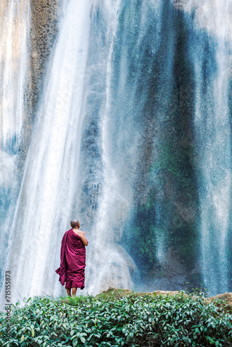 Buddhist monk praying under big waterfall, Myanmar photo