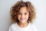 Portrait of a cute little girl with curly hair over gray background