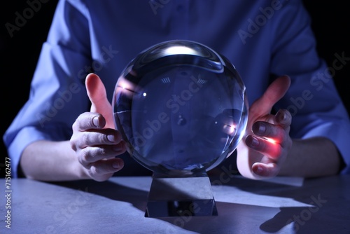Businesswoman using ball to predict future at table, closeup