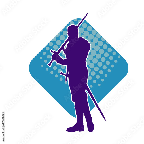 Silhouette of a male warrior wearing war armor suit in action pose using a sword weapon.