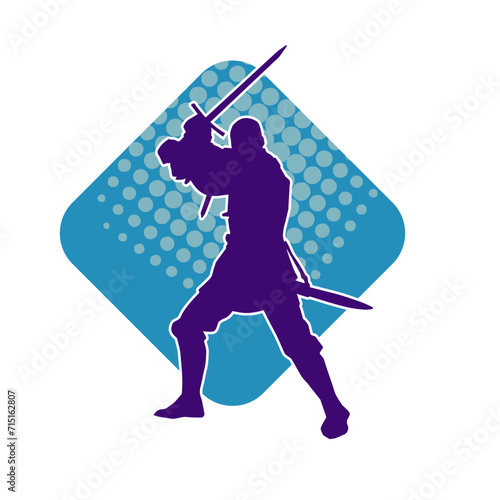 Silhouette of a male warrior wearing war armor suit in action pose using a sword weapon.