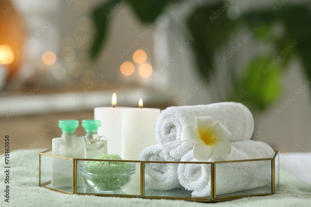 Composition with different spa products and burning candles on table indoors Composition with different spa products and burning candles on table indoors