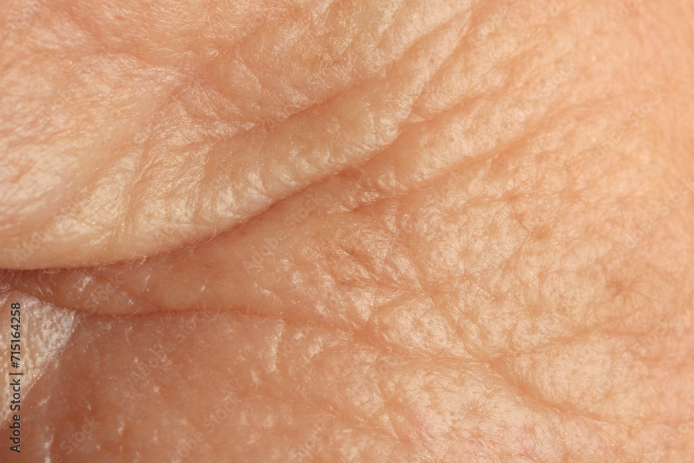 Fototapeta premium Texture of human skin with wrinkles as background, macro view