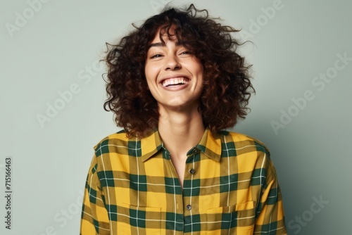Portrait of a laughing young woman in a plaid shirt.