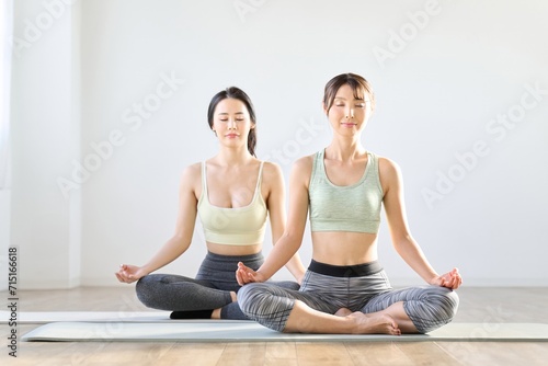 目を閉じて瞑想する2人の女性