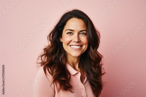 Portrait of happy young woman looking at camera over pink background.