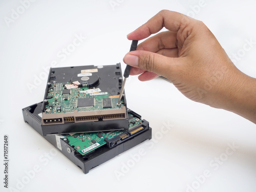 hand holding a screwdriver to repairing hard drive