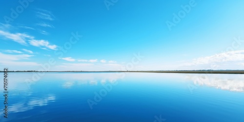 serene water surface reflecting the serene beauty of a clear blue sky