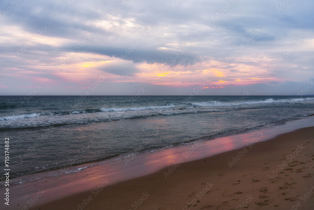 Pink sunset on the beach. Ocean, cloudy sky, and empty sandy beach at sunset Pink sunset on the beach. Ocean, cloudy sky, and empty sandy beach at sunset