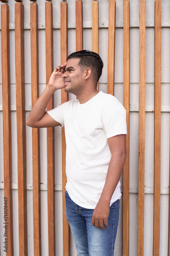 Young man in casual wear with dental braces standing against a wooden fence. Young man in casual wear with dental braces standing against a wooden fence.