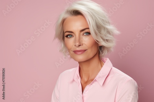 Portrait of a beautiful blonde woman with short hair on a pink background
