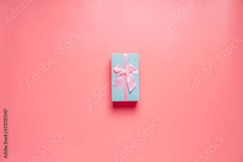 Top view photo of valentine's day decorations giftbox with silk ribbon bow on isolated pastel pink background with copyspace, concept Valentine's Day. photo